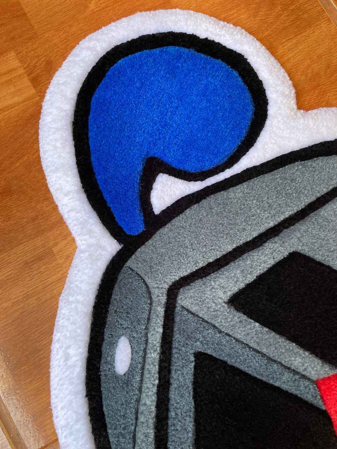 Hog-shaped rug with blue snout, gray body, black outlines and white border