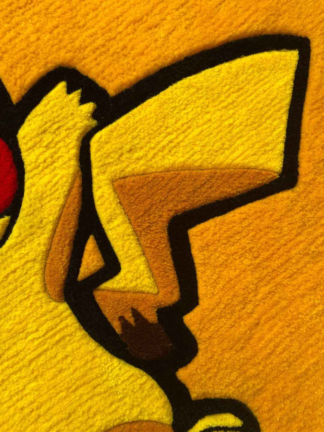 Pikachu rug close-up of paw and arm with black outline on yellow pile