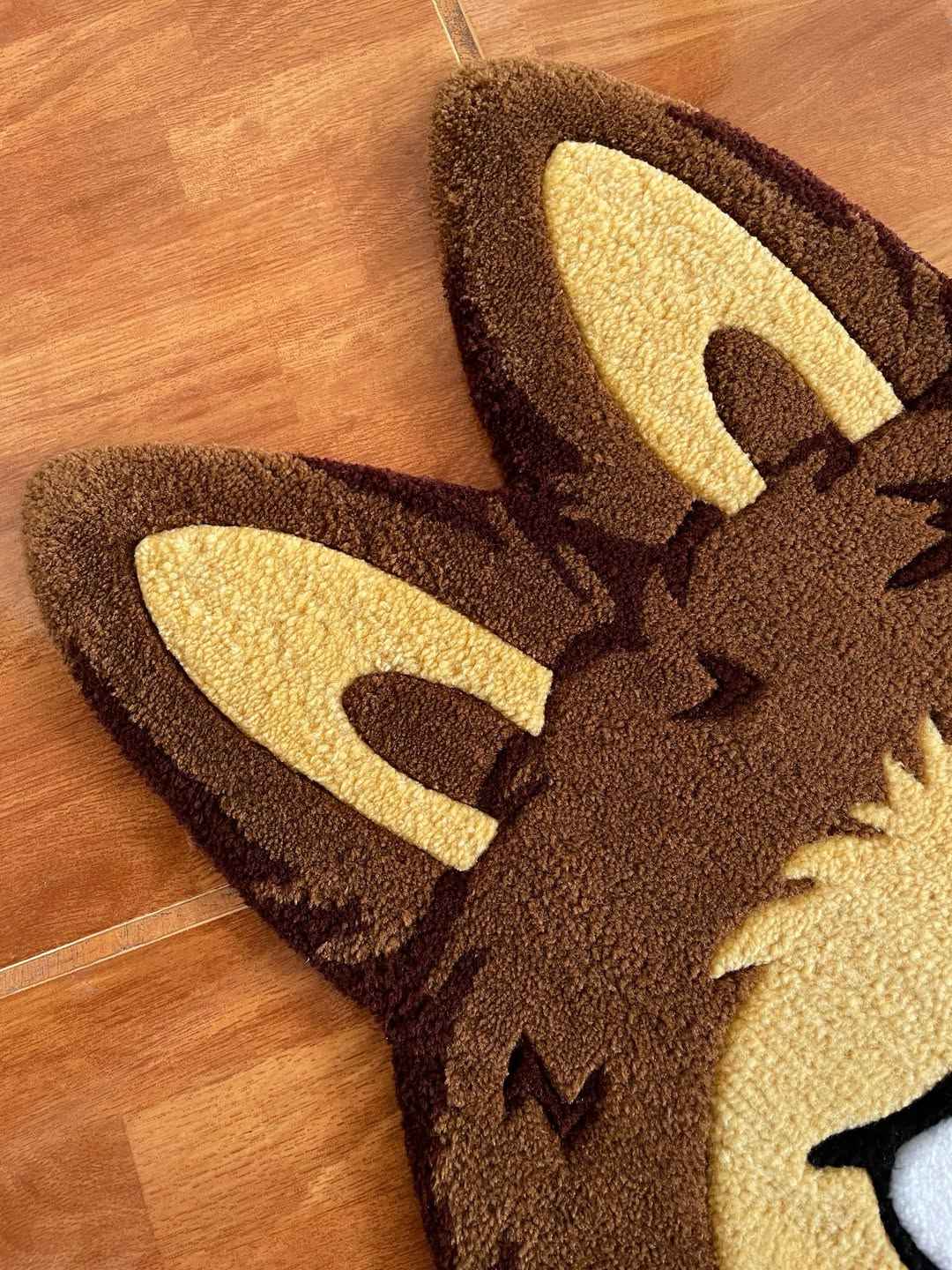 Labubu area rug partial view with dark brown and yellow cat ears and face