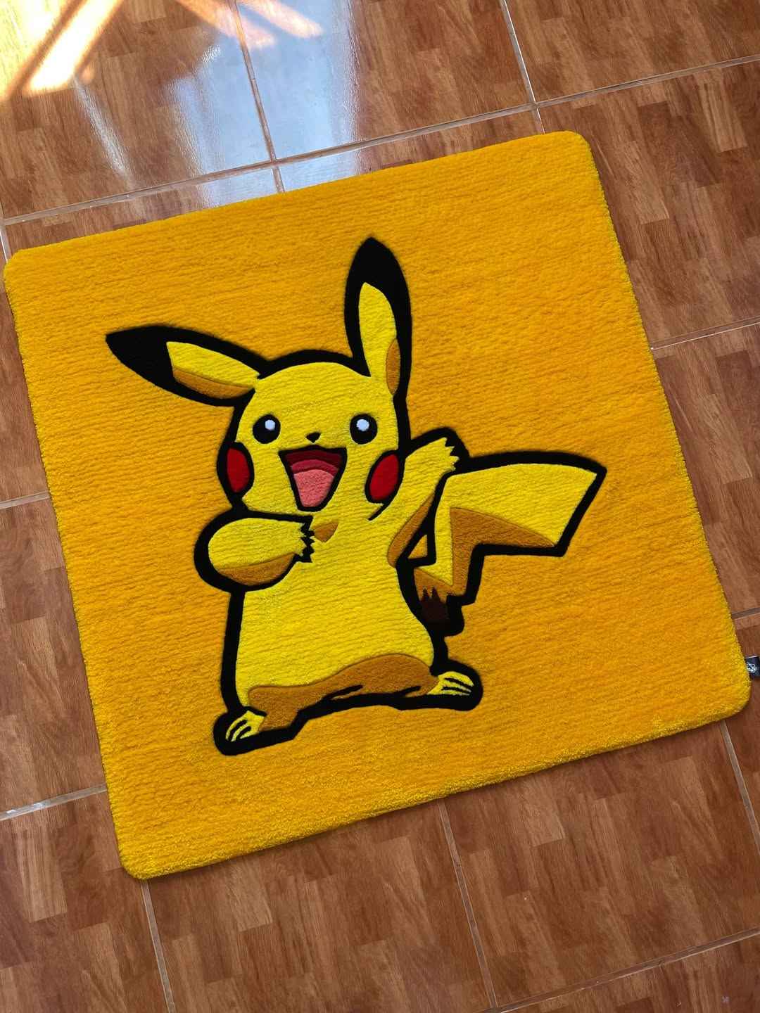Pikachu character rug in bright yellow with black outline and red cheek accents