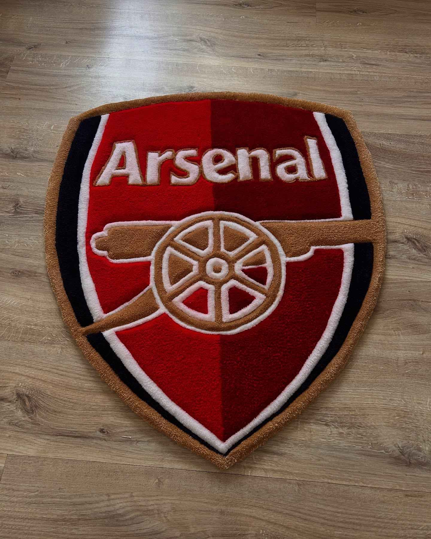 Arsenal shield football rug with red, black, and white crest and gold border