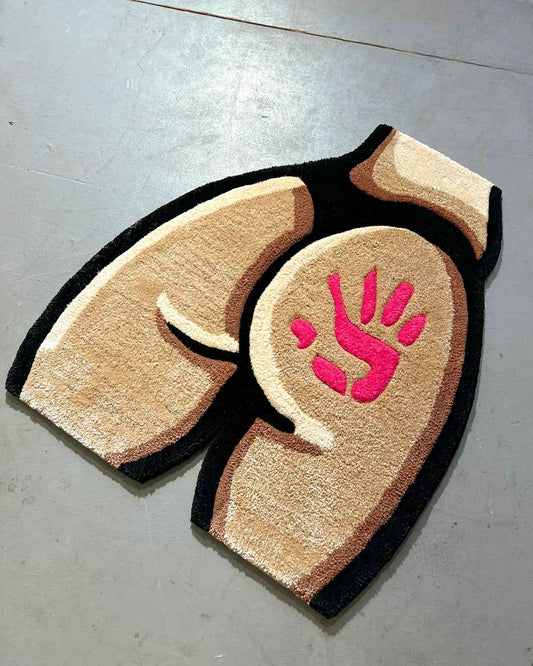 Shaped bedroom rug with beige fur texture, black edge, and pink handprint centerpiece