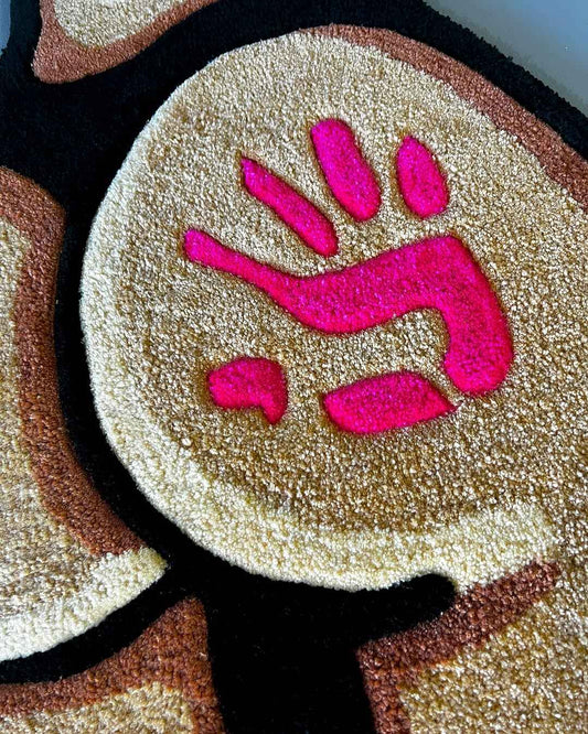 Handprint detail on beige rug pad with pink nails, framed by black outline