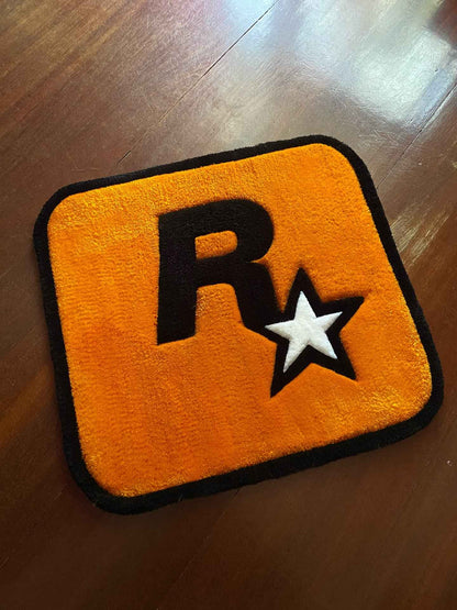 Yellow gaming rug with black border and R* logo, star accents, rounded corners
